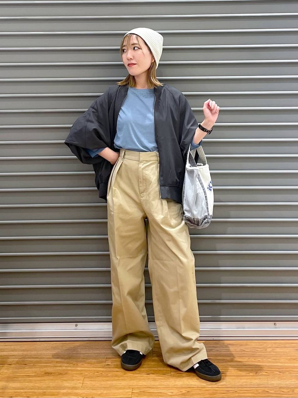 ベージュ系のチノパンツ、グレー系のブルゾン、ブラック系のスニーカーを着用したレディースの夏コーディネートの1枚目の写真