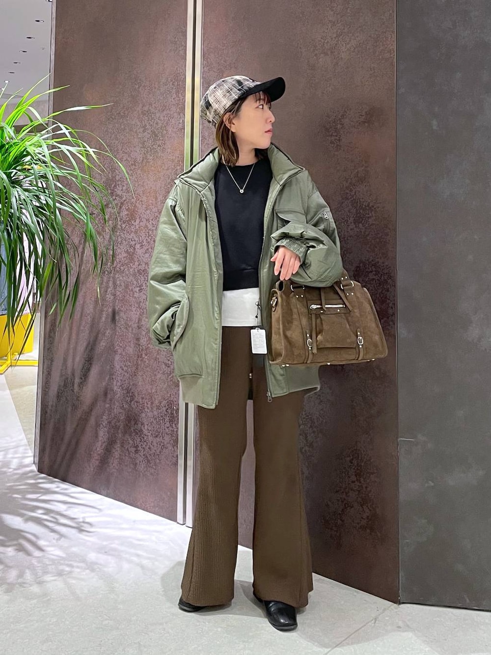 ブラウン系のボストンバッグ、ブラウン系のその他パンツ、グリーン系のブルゾンを着用したレディースの秋コーディネートの1枚目の写真