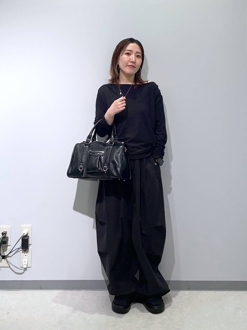 ブラック系のTシャツ/カットソー、ブラック系のサンダル、ブラック系のボストンバッグを着用したレディースの春コーディネートの1枚目の写真