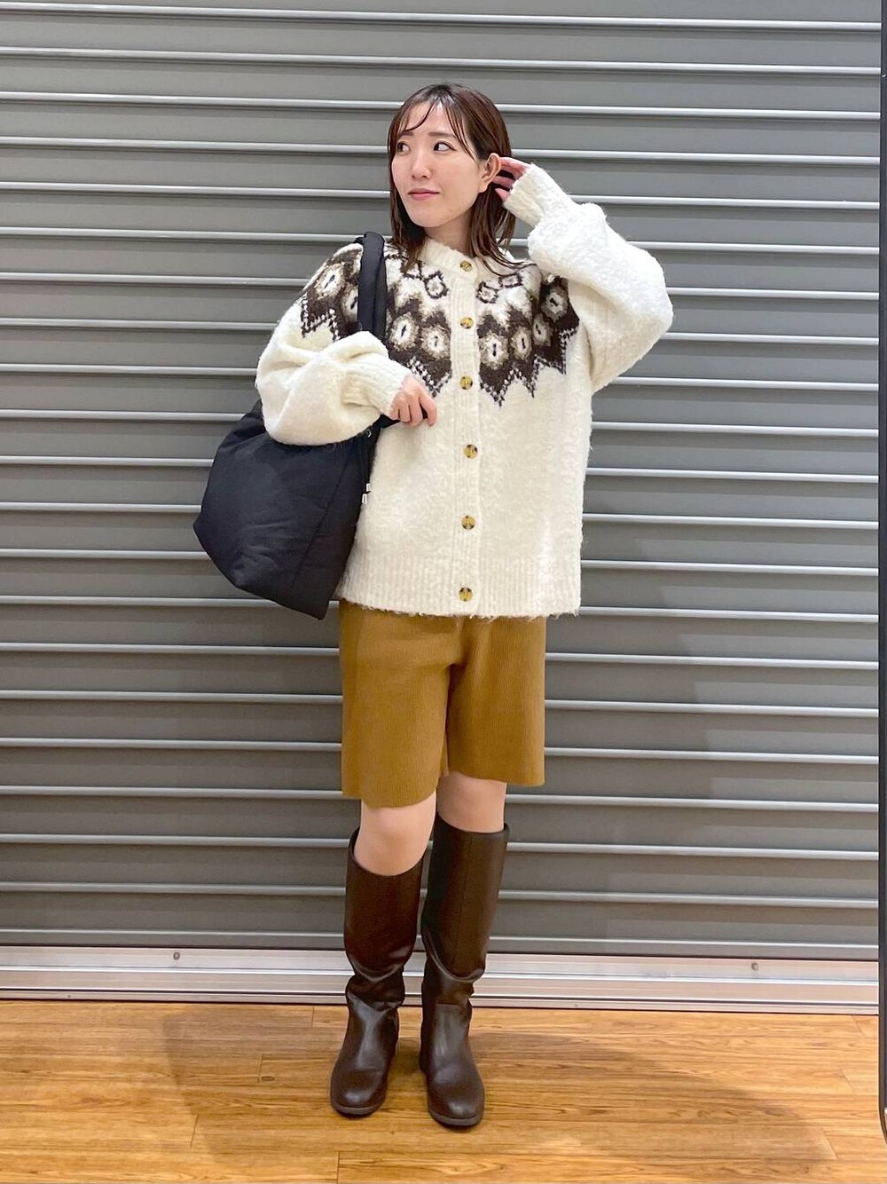 ブラウン系のその他パンツ、ブラウン系のブーツ、ブラック系のマザーズバッグを着用したレディースの冬コーディネートの1枚目の写真