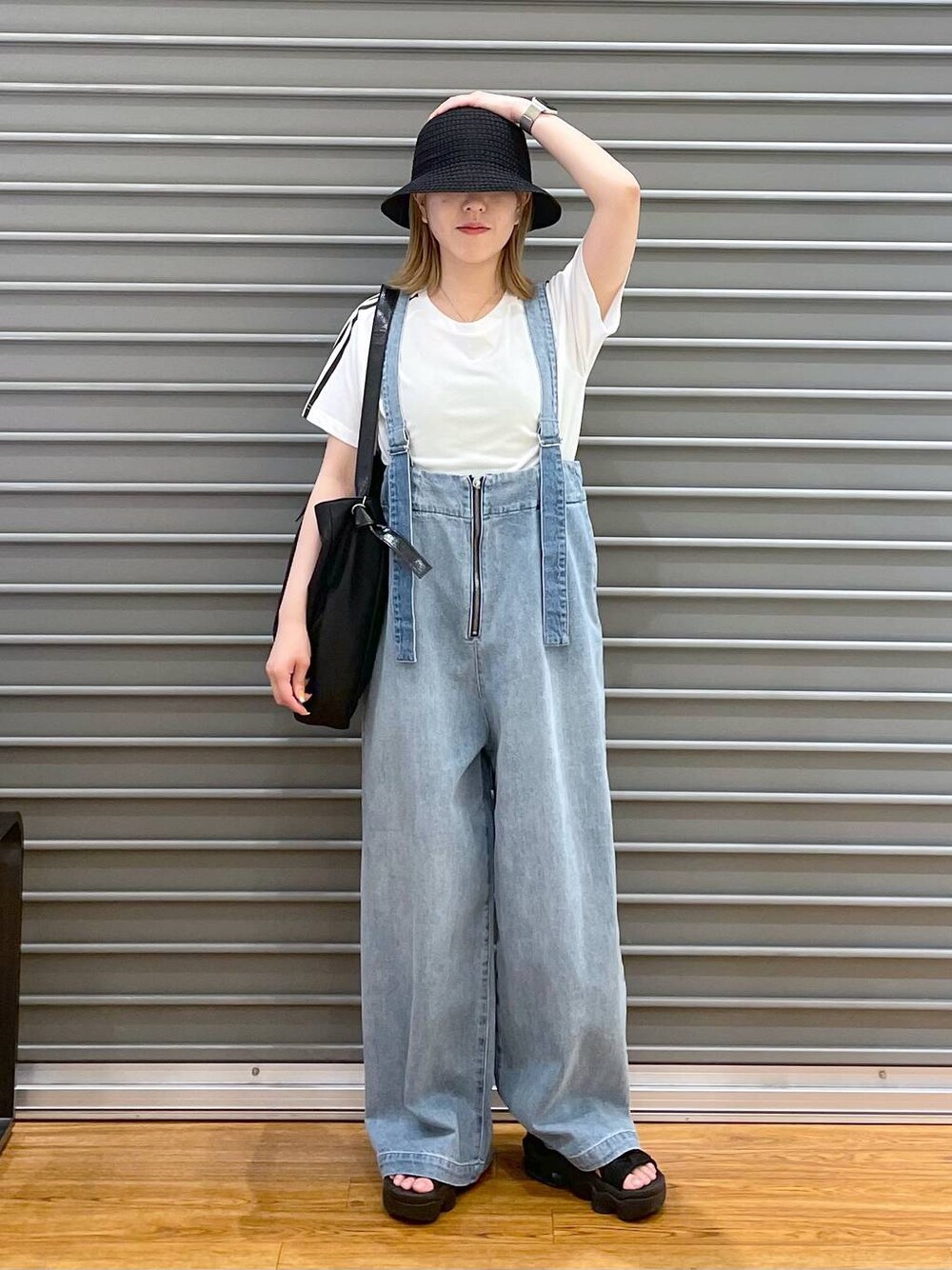 ブルー系のデニムパンツ、ブラック系のショルダーバッグ、ホワイト系のTシャツ/カットソーを着用したレディースの春コーディネートの1枚目の写真