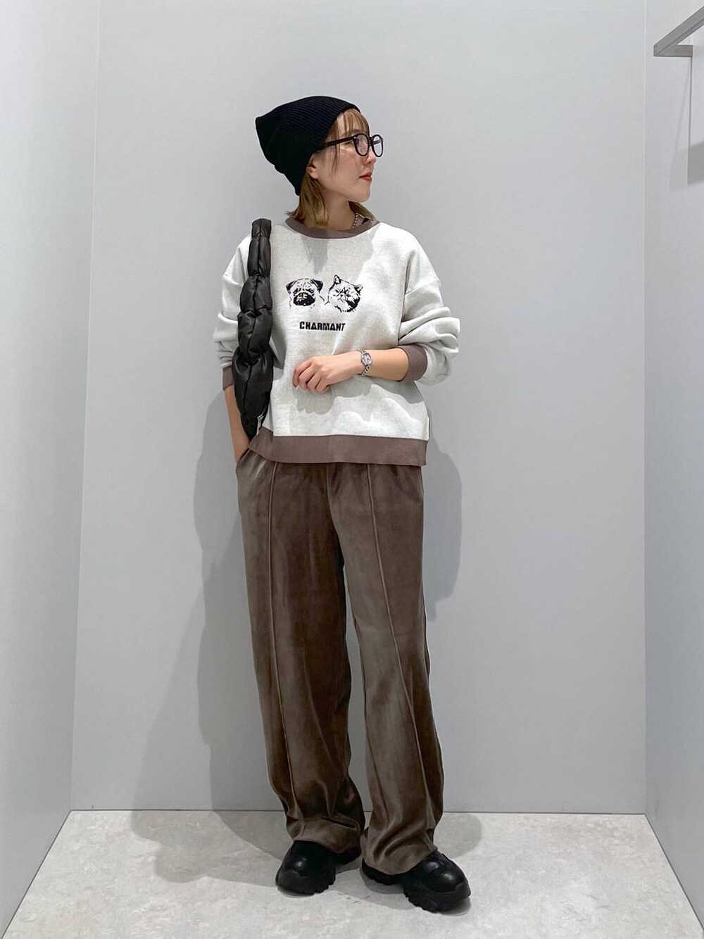 ブラウン系のその他パンツ、ブラック系のハンドバッグ、ベージュ系のニット/セーターを着用したレディースの秋コーディネートの1枚目の写真