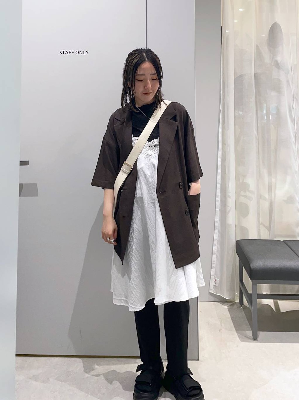 ベージュ系のワンピース、グレー系のテーラードジャケット、ブラック系のその他パンツを着用したレディースの春コーディネートの1枚目の写真