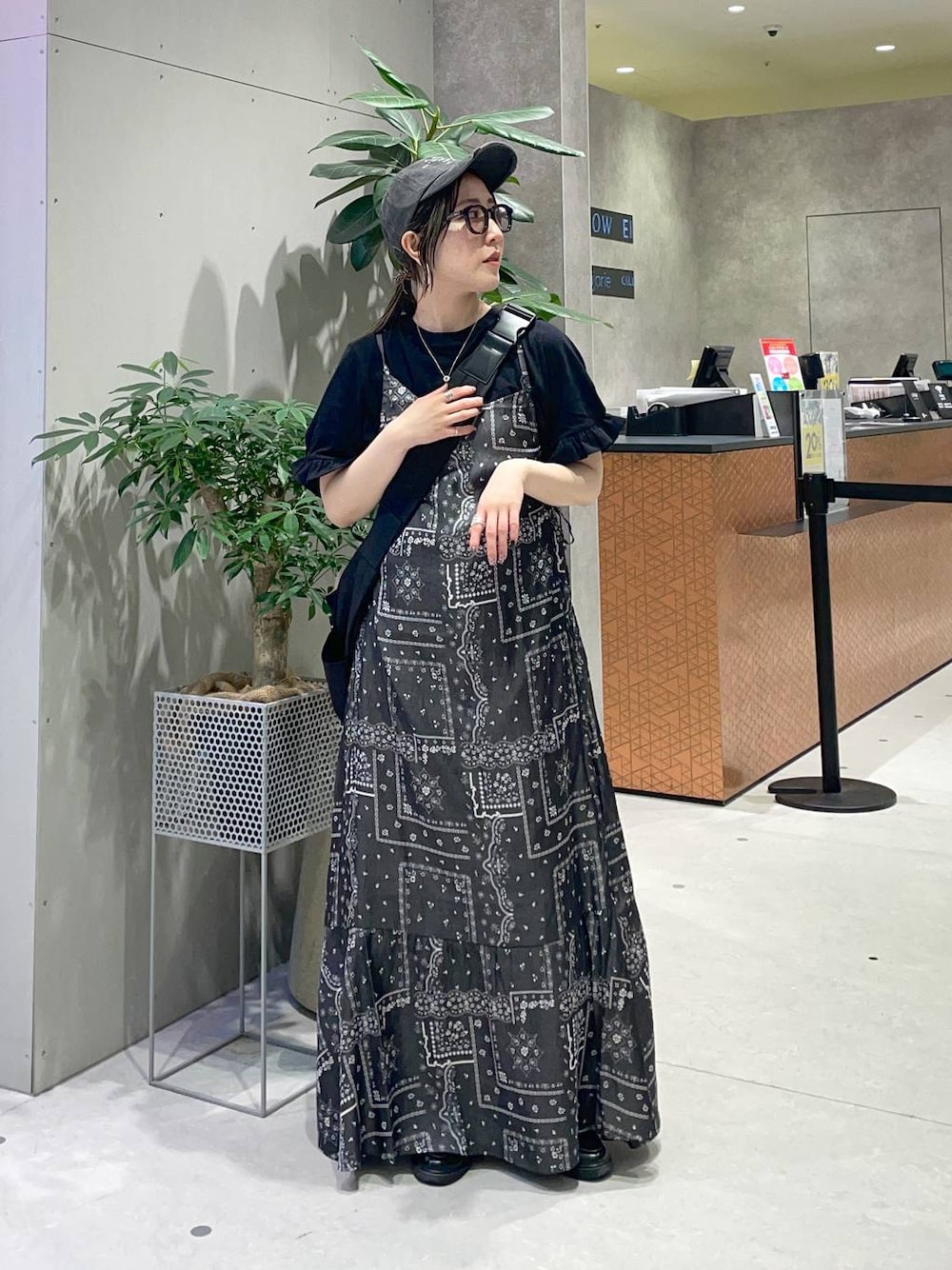 ブラック系のショルダーバッグ、ブラック系のワンピース、ブラック系のTシャツ/カットソーを着用したレディースの春コーディネートの1枚目の写真