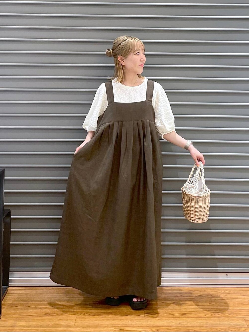 ホワイト系のかごバッグ、ホワイト系のTシャツ/カットソー、グリーン系のワンピースを着用したレディースの春コーディネートの1枚目の写真