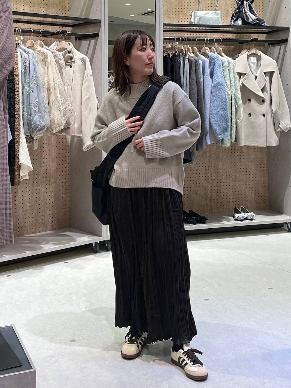 ブラック系のショルダーバッグ、ベージュ系のワンピースを着用したレディースの冬コーディネートの1枚目の写真