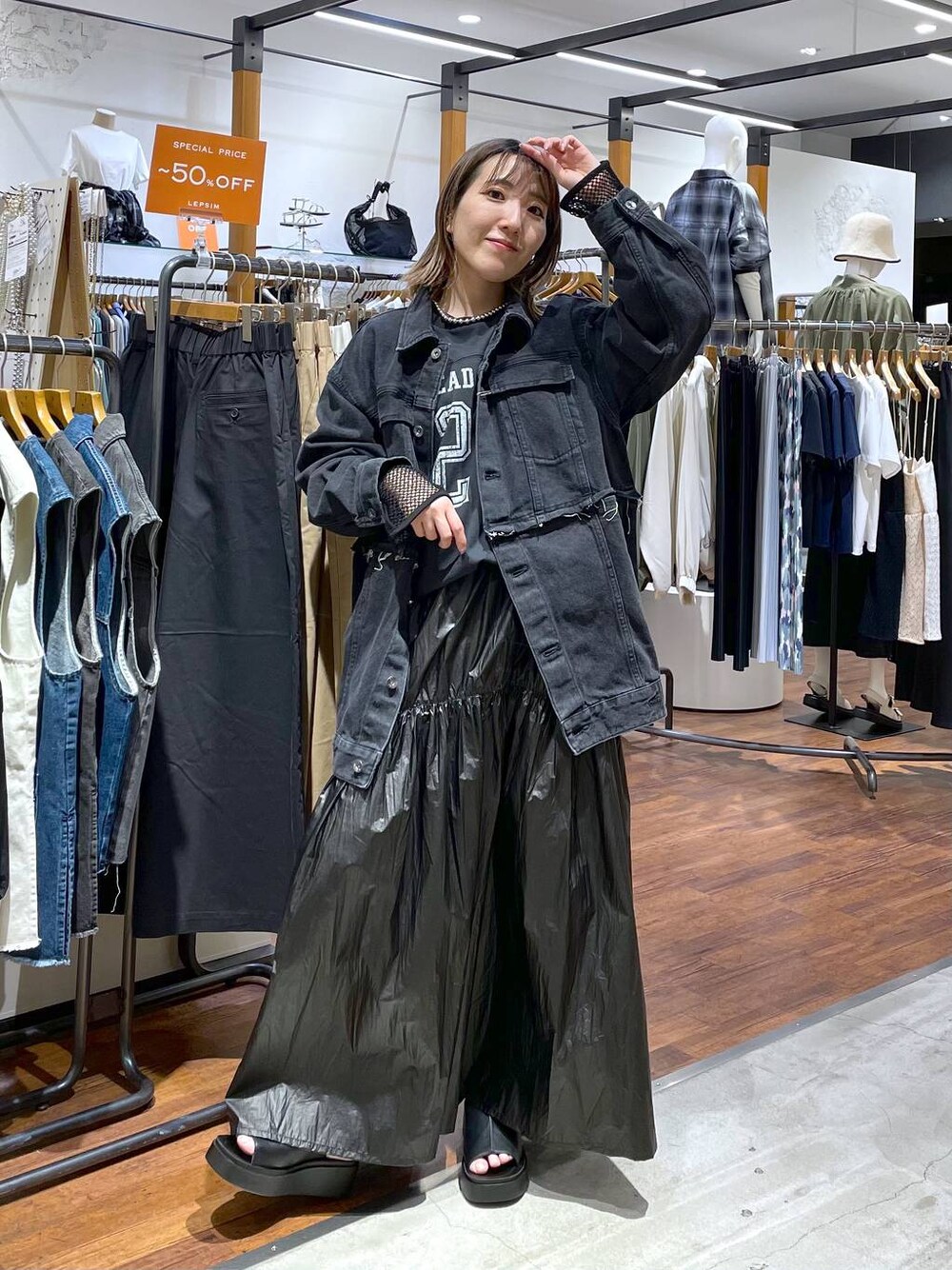 ブラック系のスカート、ブラック系のデニムジャケット、ブラック系のサンダルを着用したレディースの春コーディネートの1枚目の写真