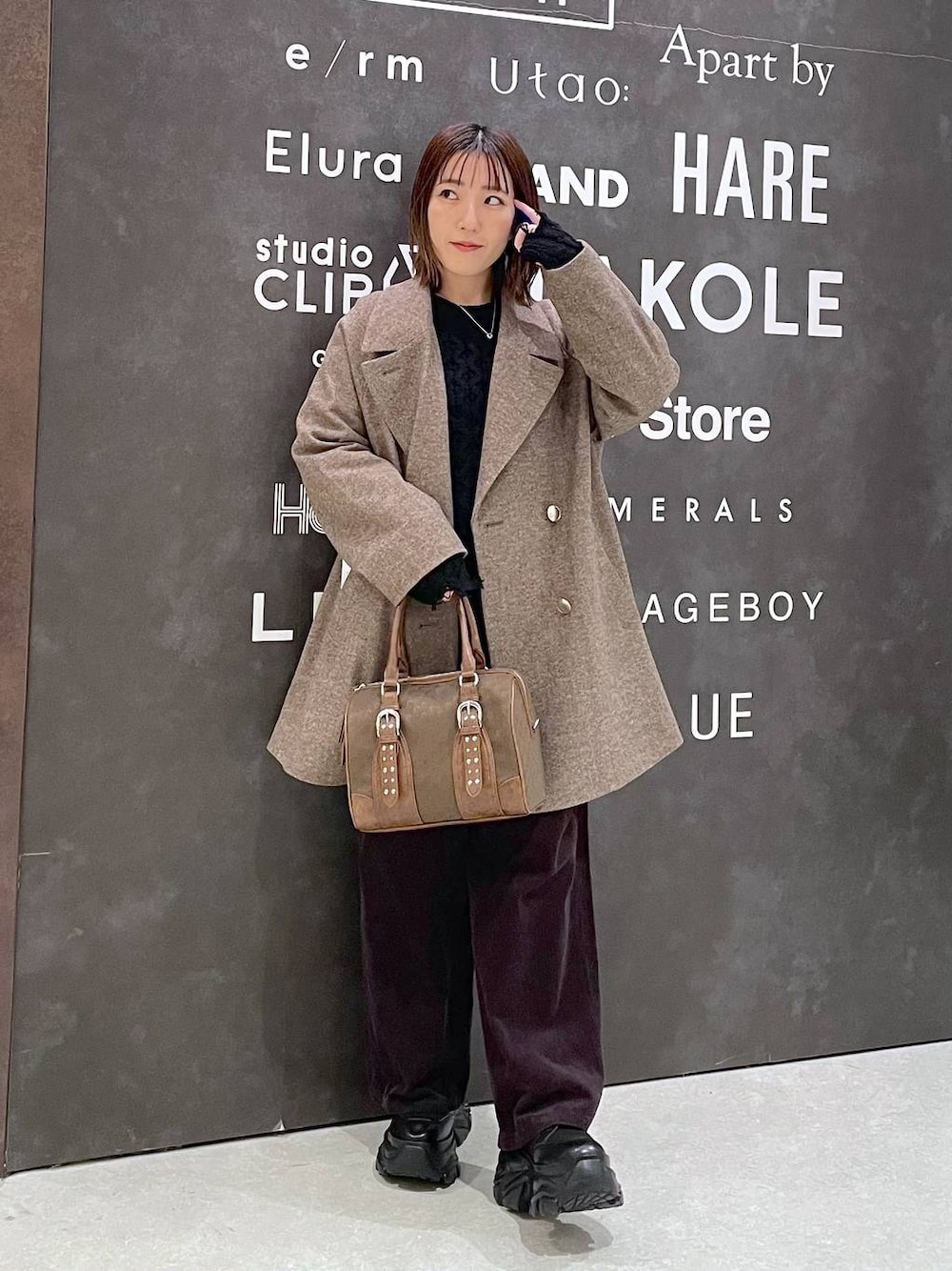 ブラック系のブーツ、ブラウン系のチェスターコート、ブラウン系のその他パンツを着用したレディースの秋コーディネートの1枚目の写真