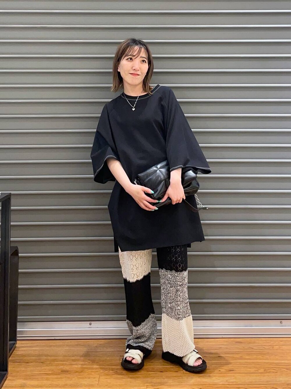 ブラック系のショルダーバッグ、グレー系のその他パンツ、ホワイト系のサンダルを着用したレディースの春コーディネートの1枚目の写真