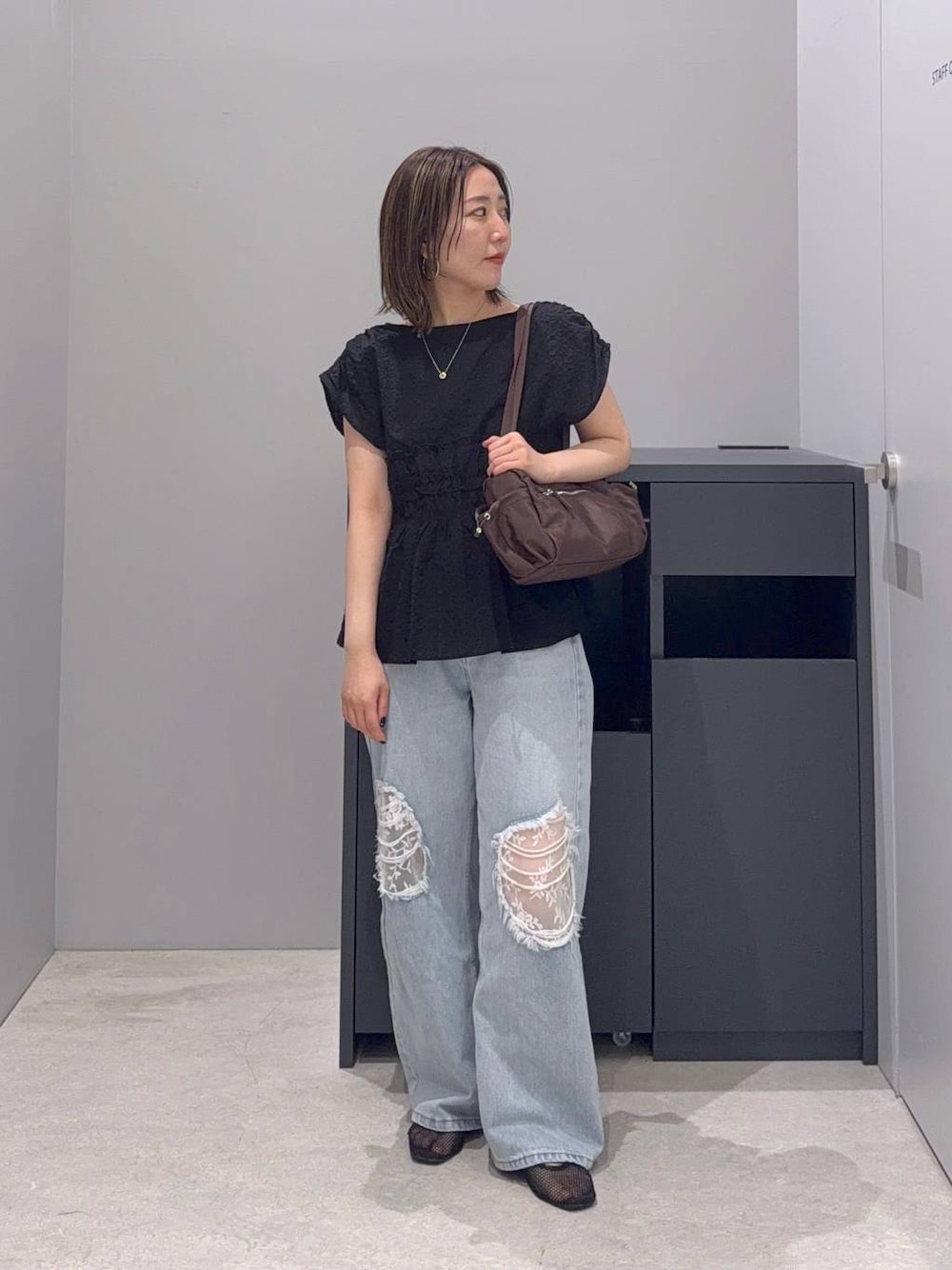 ブルー系のデニムパンツ、ブラック系のシャツ/ブラウス、ブラウン系のボストンバッグを着用したレディースの夏コーディネートの1枚目の写真