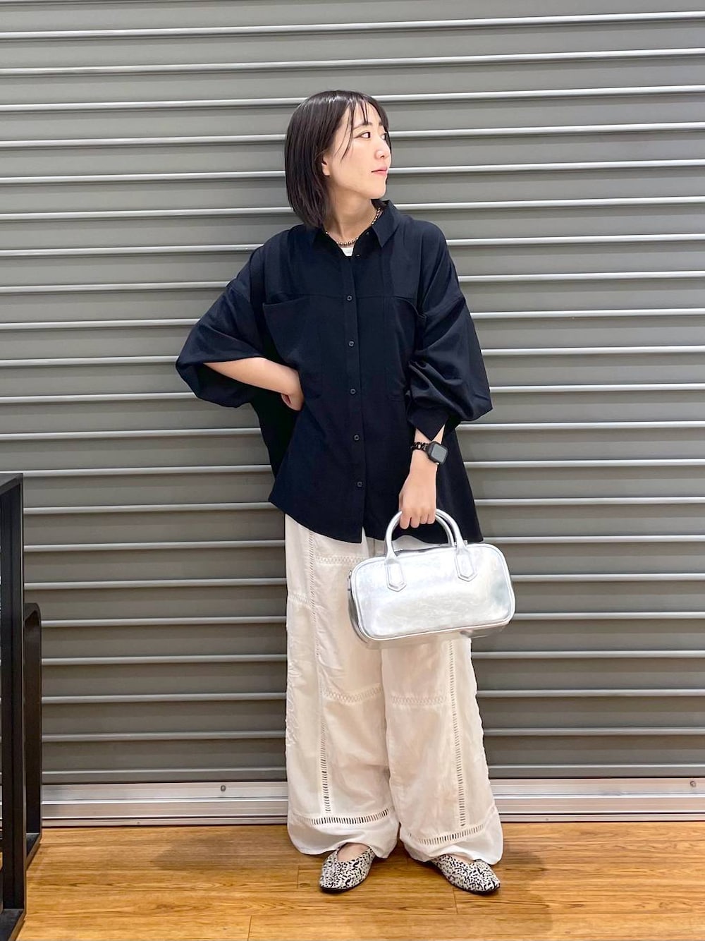 シルバー系のボストンバッグ、ホワイト系のその他パンツ、ホワイト系のパンプスを着用したレディースの秋コーディネートの1枚目の写真