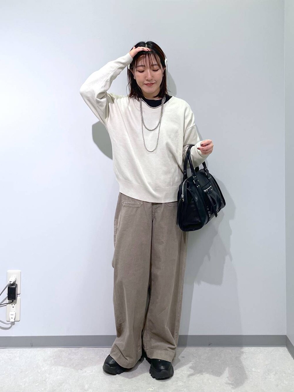 ブラック系のボストンバッグ、ベージュ系のその他パンツ、グレー系のニット/セーターを着用したレディースの冬コーディネートの1枚目の写真