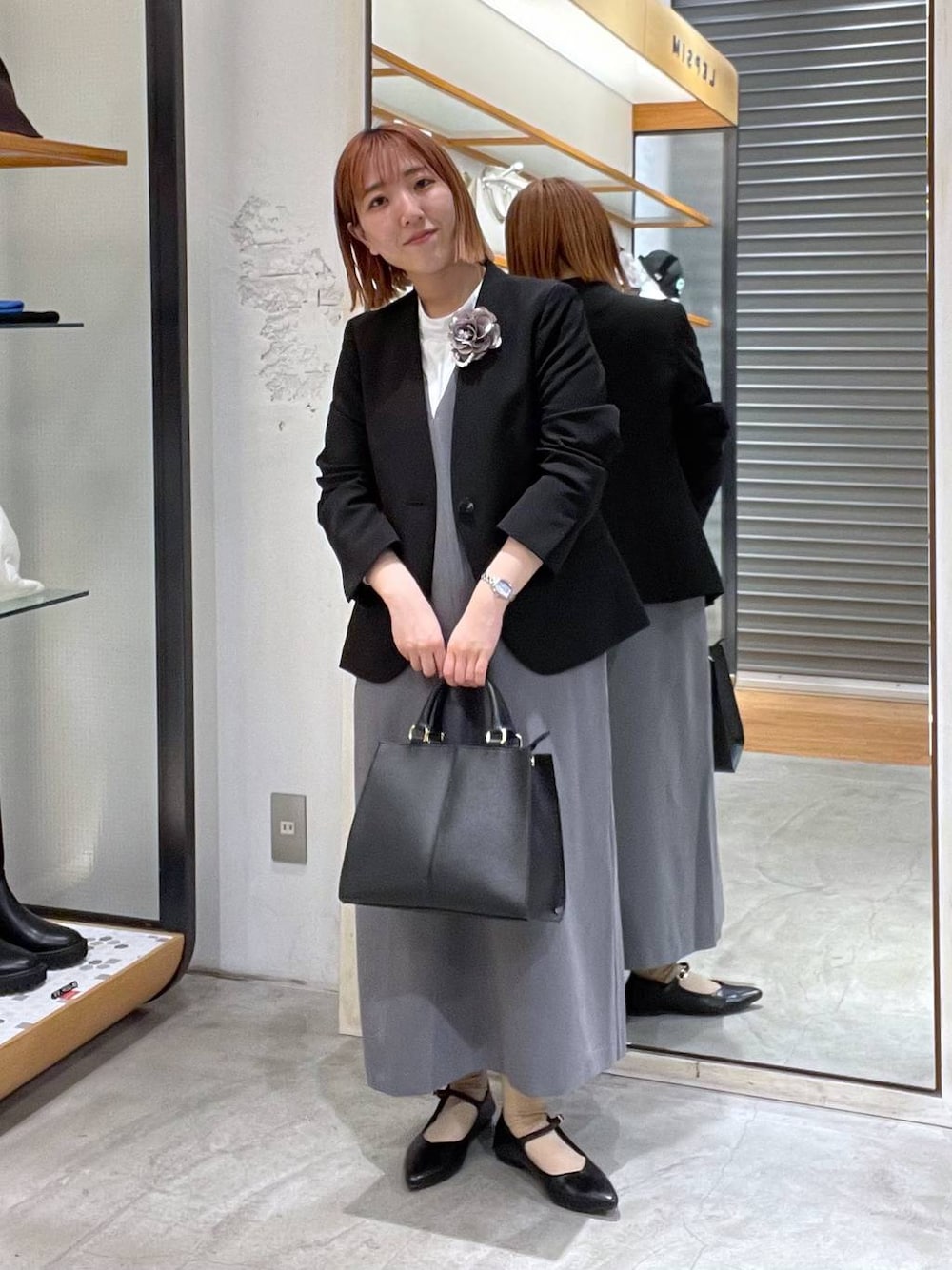 ブラック系のノーカラージャケット、ホワイト系のシャツ/ブラウス、ブラック系のショルダーバッグを着用したレディースの冬コーディネートの1枚目の写真