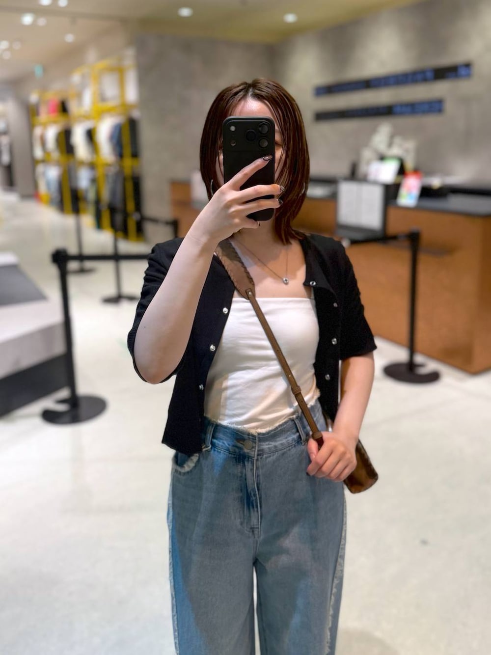 ブルー系のデニムパンツ、ブラック系のTシャツ/カットソー、ブラウン系のショルダーバッグを着用したレディースの夏コーディネートの1枚目の写真