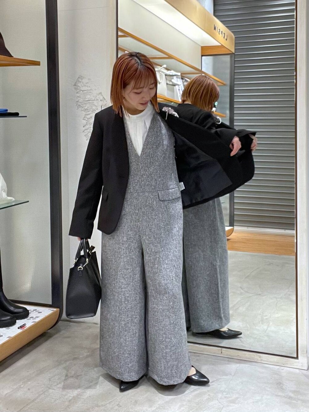 ブラック系のノーカラージャケット、ホワイト系のサロペット/オーバーオール、ホワイト系のシャツ/ブラウスを着用したレディースの冬コーディネートの1枚目の写真