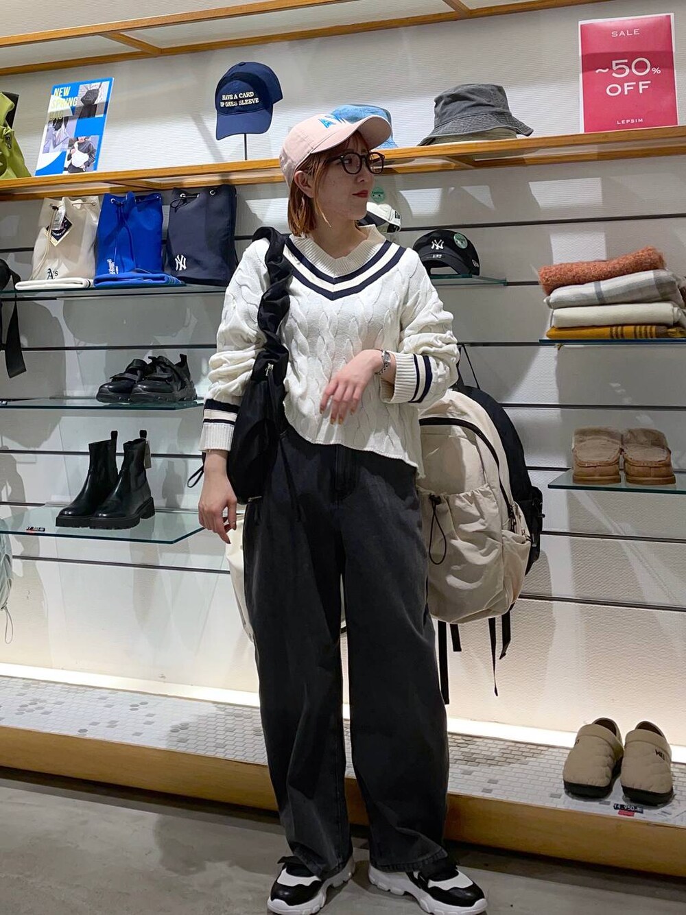 ホワイト系のニット/セーター、ブラック系のデニムパンツ、ホワイト系のスニーカーを着用したレディースの冬コーディネートの1枚目の写真