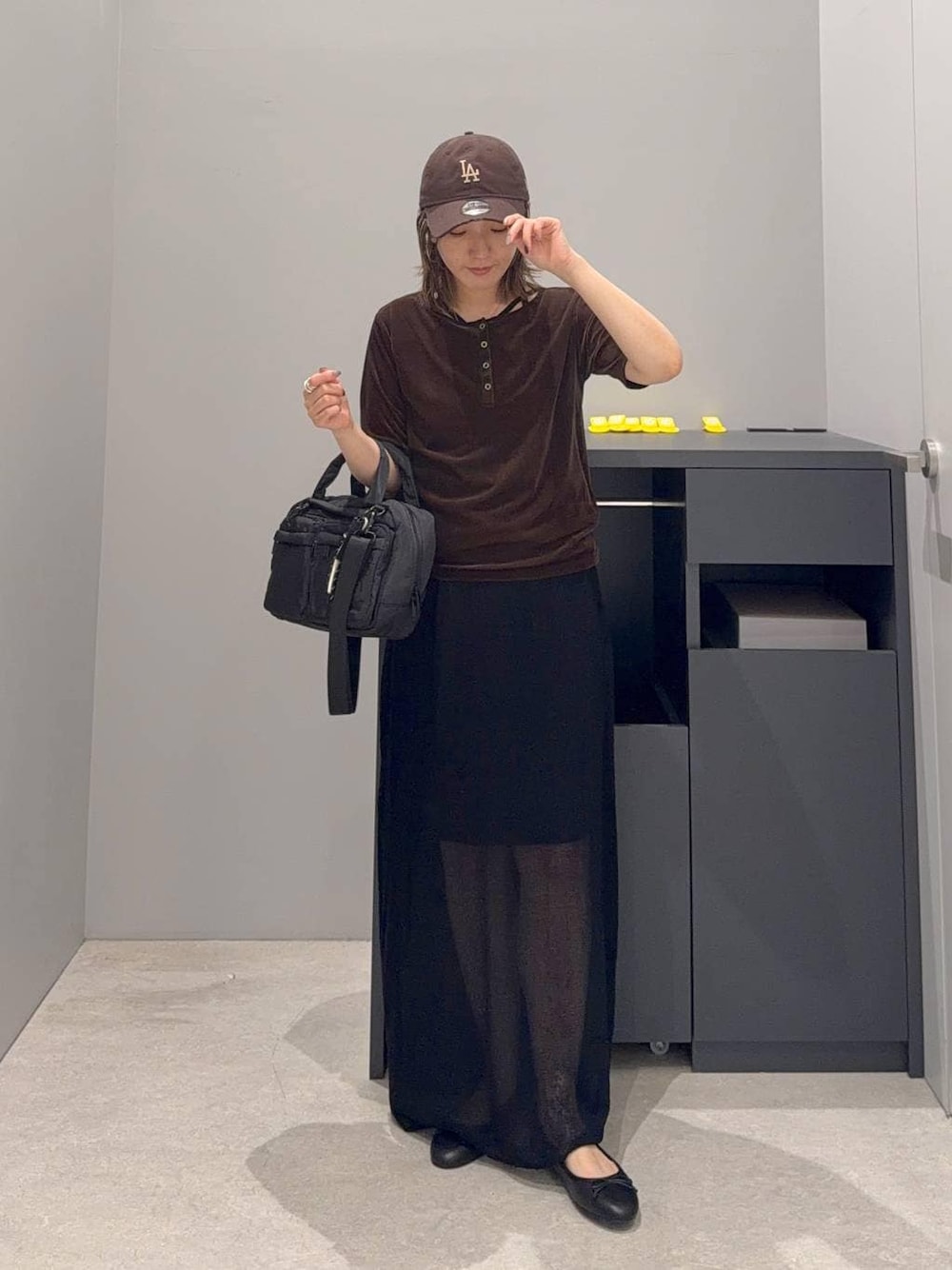 ブラック系のバレエシューズ、ブラック系のスカート、ブラック系のボストンバッグを着用したレディースの夏コーディネートの1枚目の写真