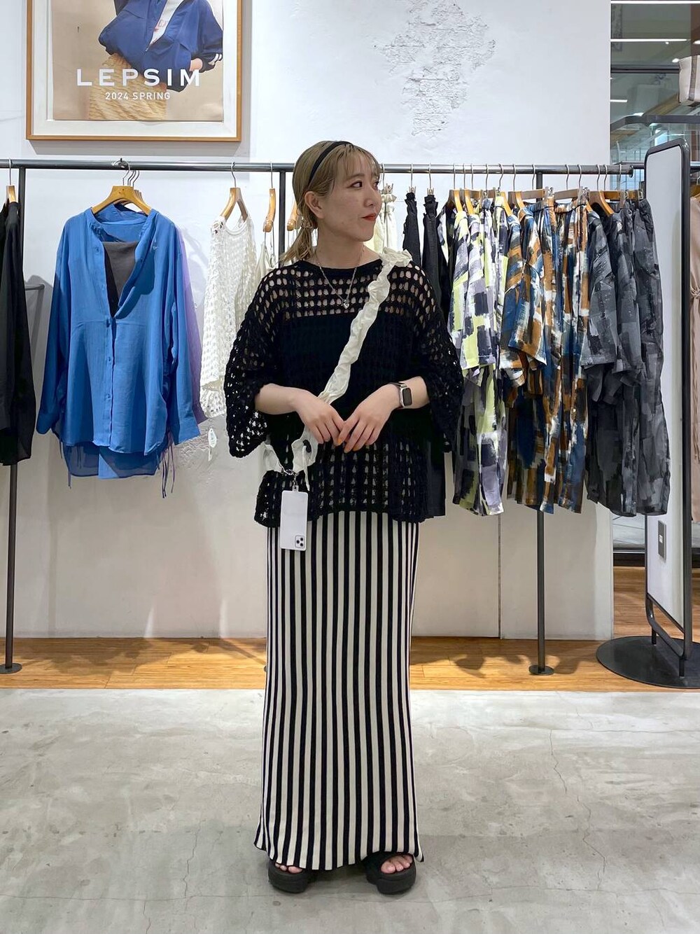 ホワイト系のスカート、パープル系のニット/セーター、シルバー系のネックレスを着用したレディースの春コーディネートの1枚目の写真