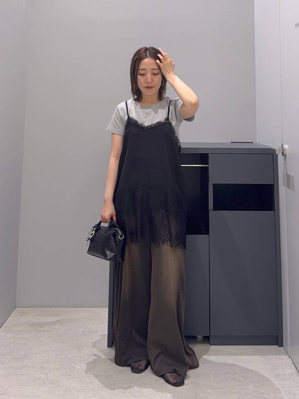 ブラウン系のデニムパンツ、ブラック系のボストンバッグ、ブラック系のTシャツ/カットソーを着用したレディースの夏コーディネートの1枚目の写真