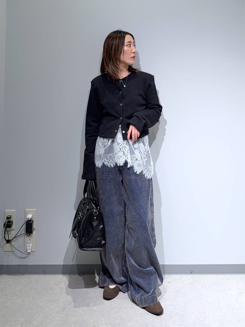 ブラック系のカーディガン/ボレロ、ブラウン系のパンプス、ブラック系のボストンバッグを着用したレディースの秋コーディネートの1枚目の写真