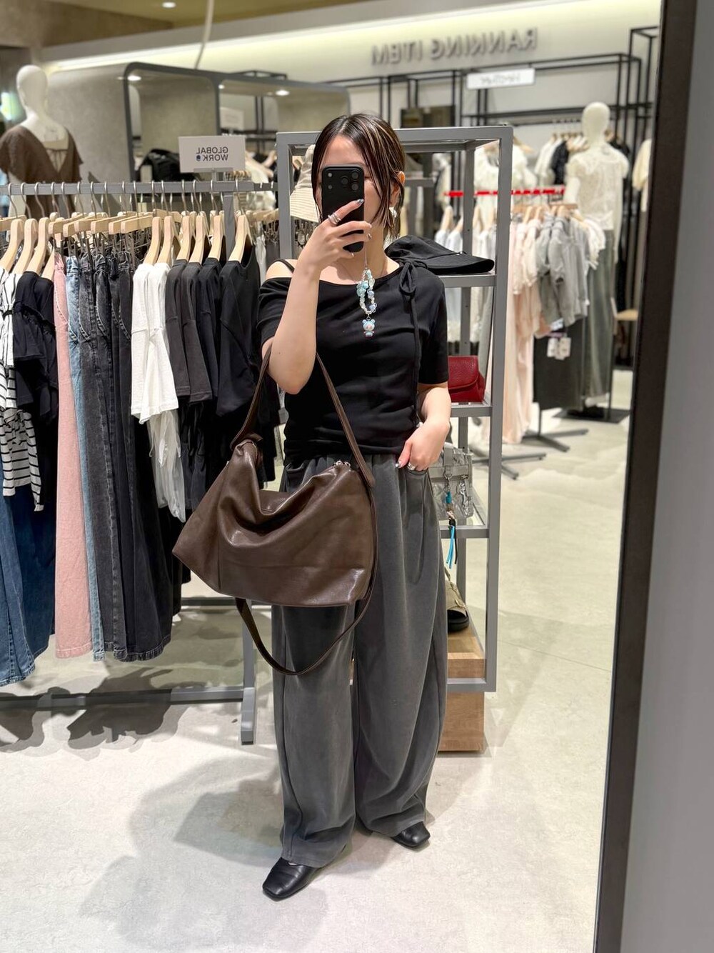 ブラウン系のショルダーバッグ、グレー系のスウェットパンツ、ブラック系のTシャツ/カットソーを着用したレディースの夏コーディネートの1枚目の写真