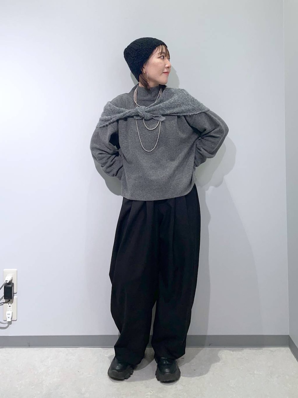 グレー系のニット/セーター、シルバー系のネックレス、グレー系のストール/ショールを着用したレディースの冬コーディネートの1枚目の写真