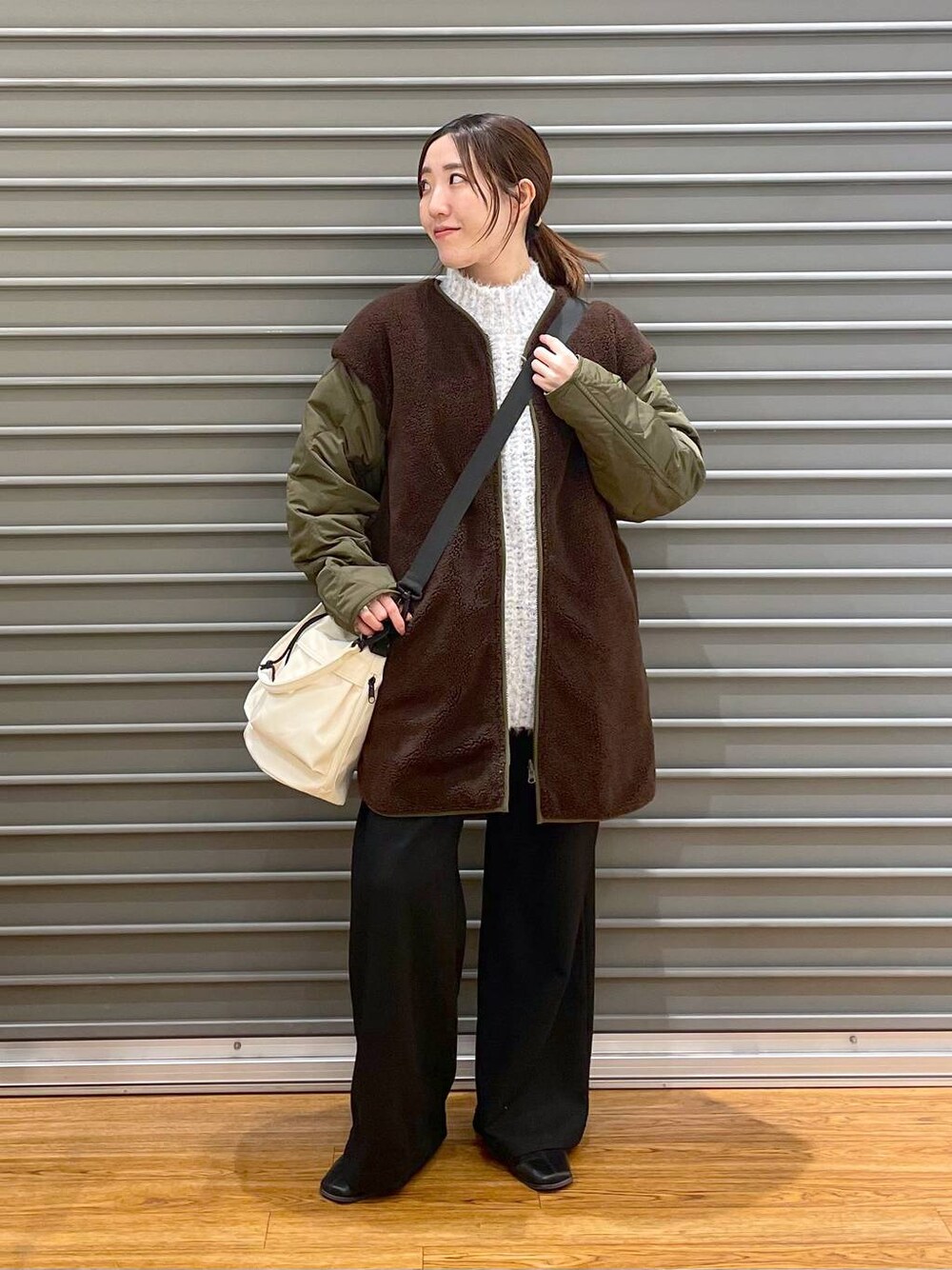 ブラック系のその他パンツ、ホワイト系のショルダーバッグ、グリーン系のマタニティウェア/グッズを着用したレディースの冬コーディネートの1枚目の写真