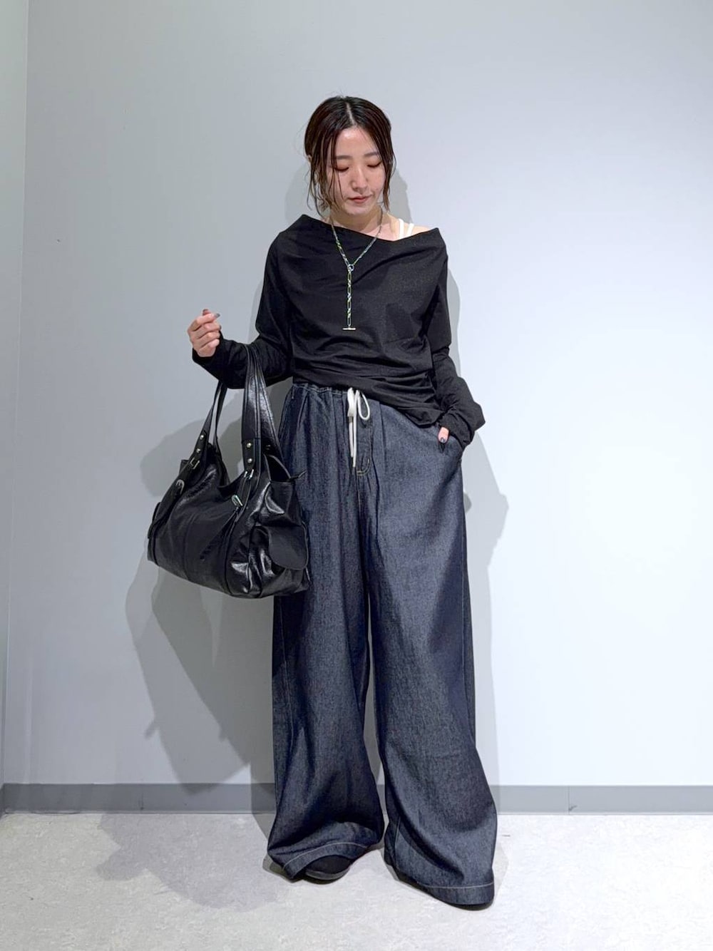 ブラック系のパンプス、ブラック系のTシャツ/カットソー、ブラック系のトートバッグを着用したレディースの秋コーディネートの1枚目の写真