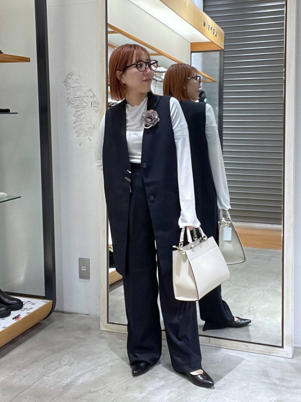 ホワイト系のTシャツ/カットソー、ホワイト系のショルダーバッグ、ブラック系のパンプスを着用したレディースの冬コーディネートの1枚目の写真