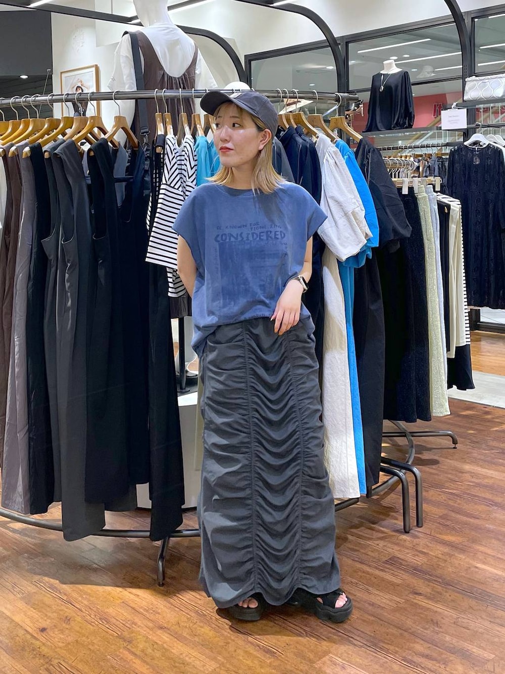 ブルー系のTシャツ/カットソー、グレー系のスカートを着用したレディースの夏コーディネートの1枚目の写真