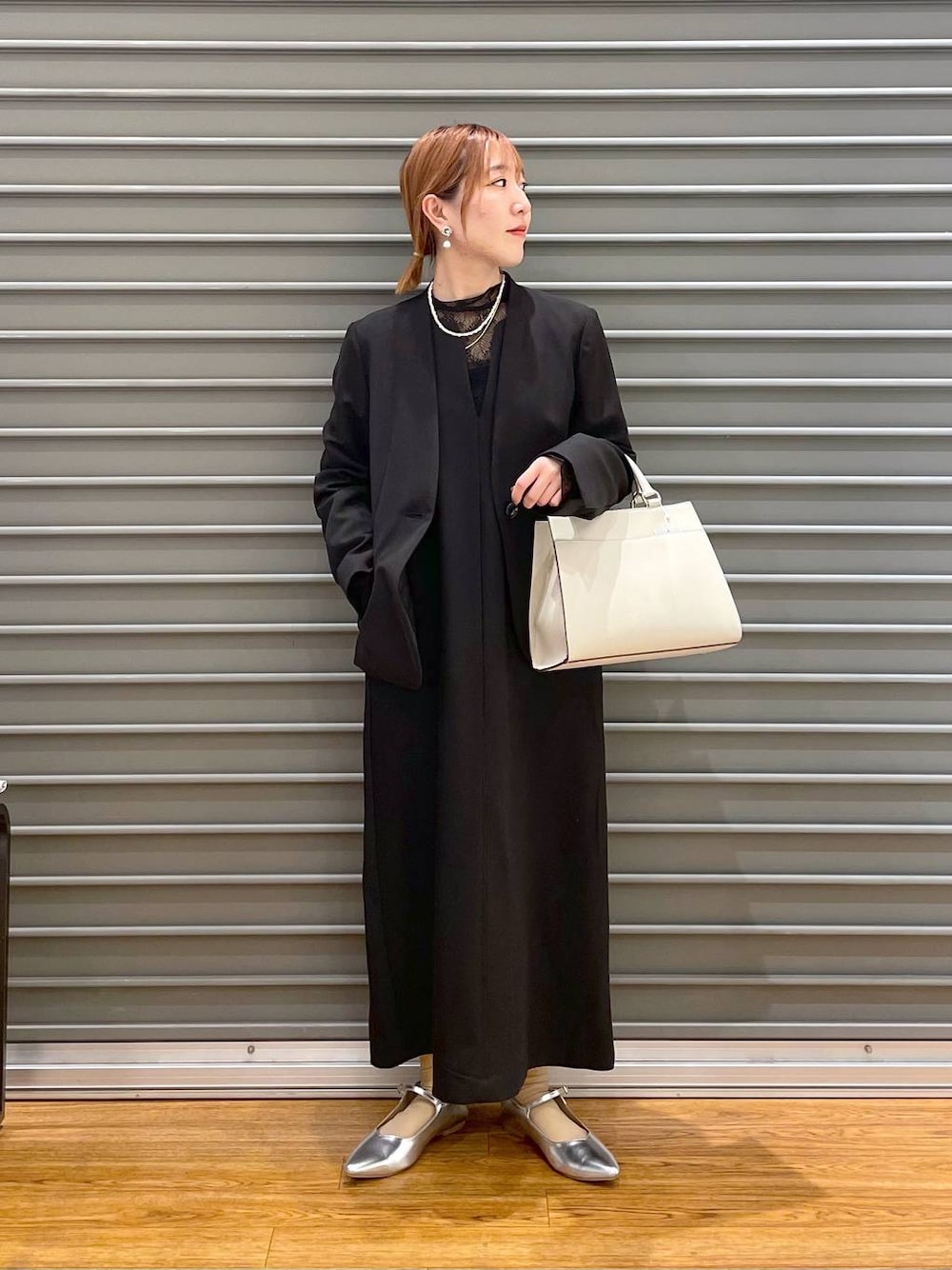 ブラック系のノーカラージャケット、ホワイト系のショルダーバッグ、グレー系のパンプスを着用したレディースの冬コーディネートの1枚目の写真