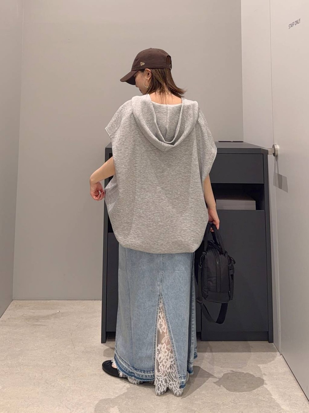 ブルー系のデニムスカート、その他のベスト、ブラック系のボストンバッグを着用したレディースの夏コーディネートの1枚目の写真