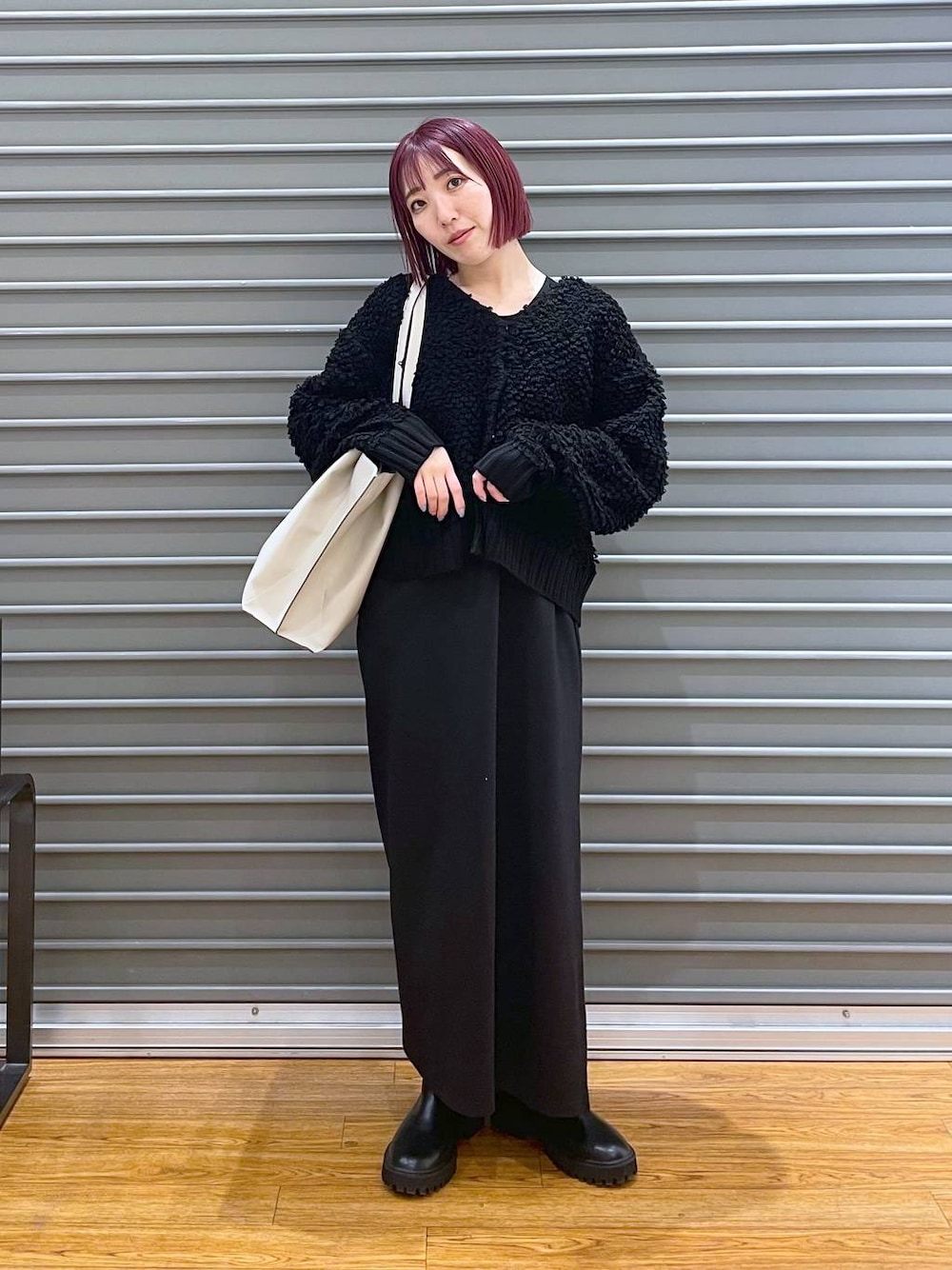 ブラック系のワンピース、ブラック系のブーツ、ベージュ系のトートバッグを着用したレディースの冬コーディネートの1枚目の写真