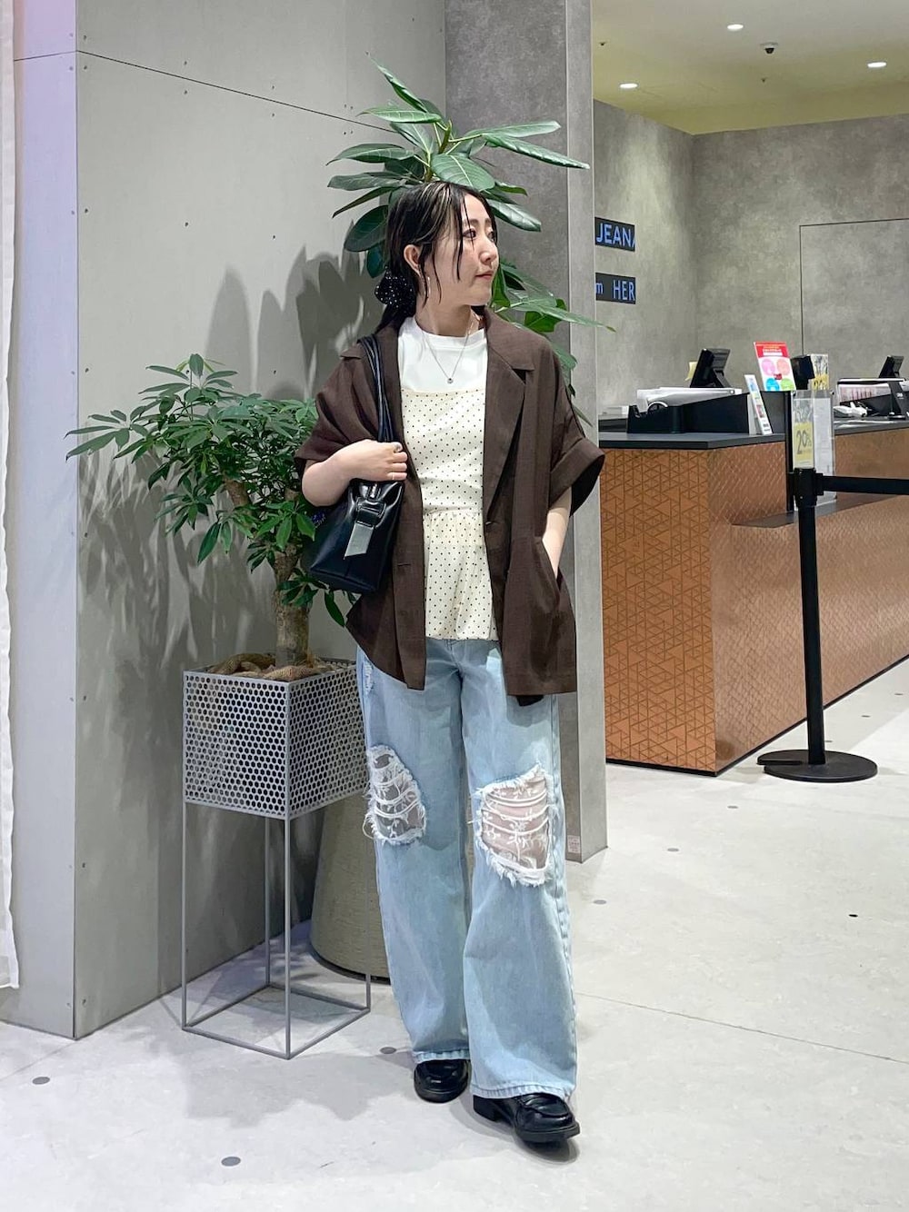 ブラック系のボストンバッグ、ブルー系のデニムパンツ、ホワイト系のTシャツ/カットソーを着用したレディースの春コーディネートの1枚目の写真