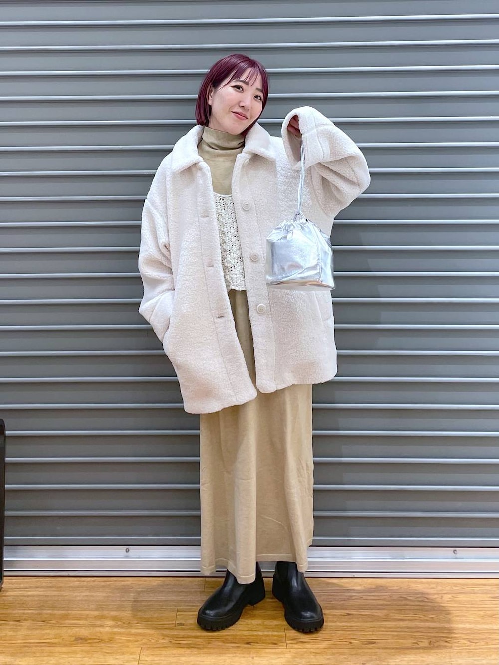 ホワイト系のブルゾン、ホワイト系のワンピース、ブラック系のブーツを着用したレディースの冬コーディネートの1枚目の写真