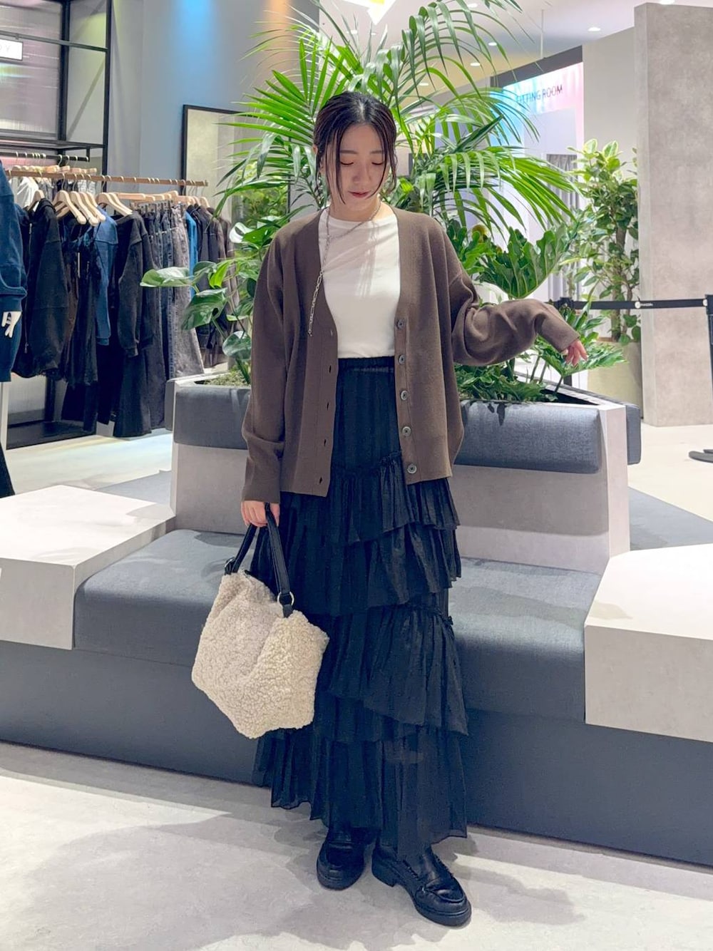 ホワイト系のショルダーバッグ、ホワイト系のTシャツ/カットソー、ブラック系のスカートを着用したレディースの秋コーディネートの1枚目の写真