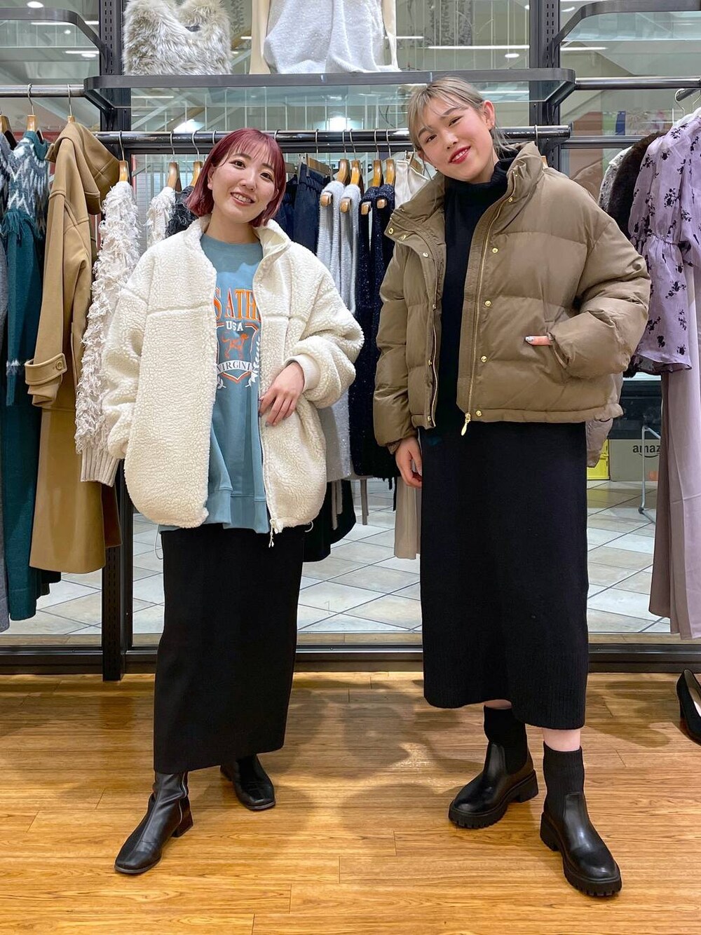 ブラック系のスカート、グリーン系のスウェット、ブラック系のブーツを着用したレディースの冬コーディネートの1枚目の写真