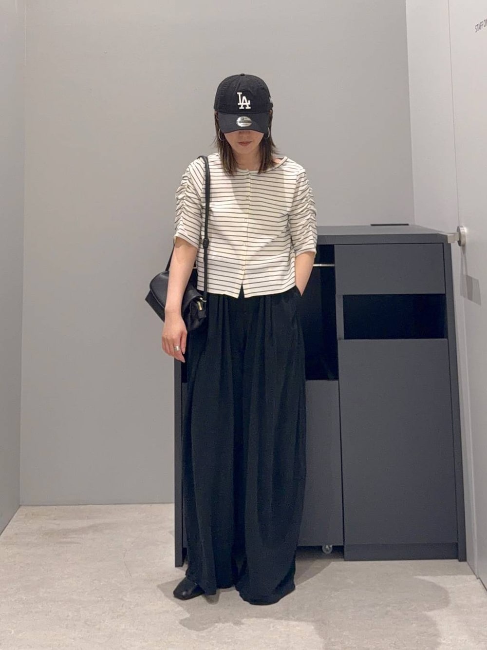ブラック系のその他パンツ、ブラック系のショルダーバッグ、ホワイト系のTシャツ/カットソーを着用したレディースの夏コーディネートの1枚目の写真