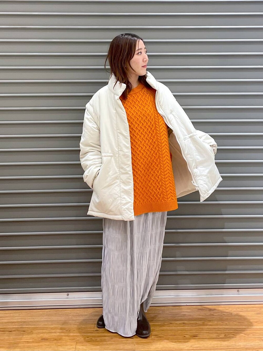 ホワイト系のその他アウター、ブラウン系のブーツ、オレンジ系のその他トップスを着用したレディースの冬コーディネートの1枚目の写真