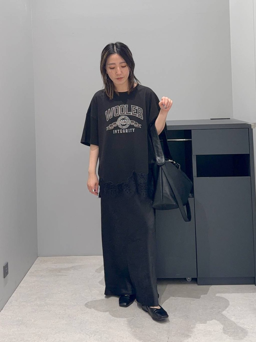 ブラック系のスカート、ブラック系のショルダーバッグ、グレー系のTシャツ/カットソーを着用したレディースの夏コーディネートの1枚目の写真