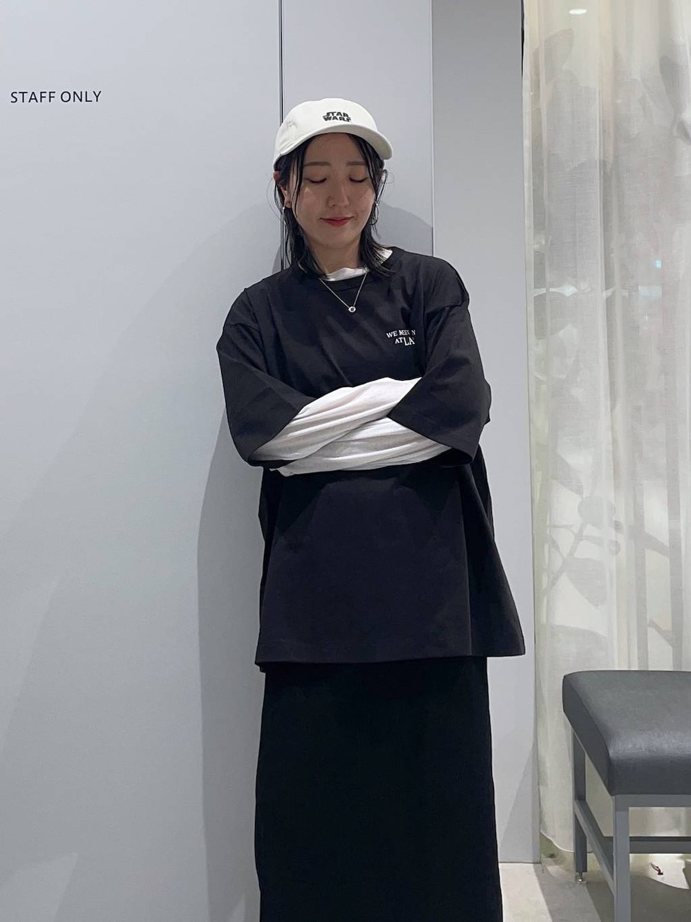ブラック系のスカート、ホワイト系のTシャツ/カットソー、ブラック系のサンダルを着用したレディースの春コーディネートの1枚目の写真