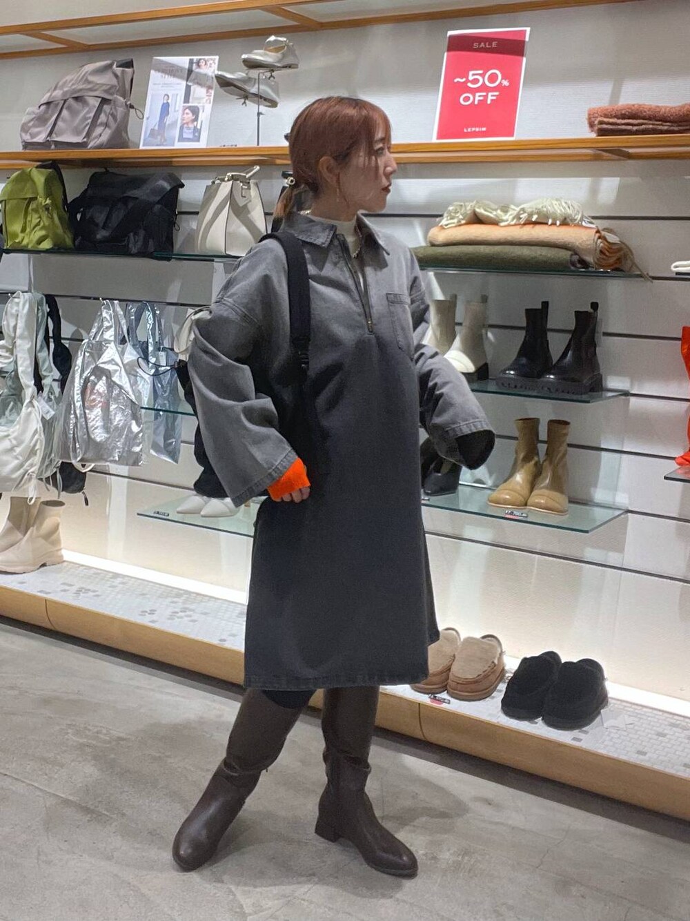 ブラウン系のブーツ、ブラック系のバックパック/リュック、ホワイト系のニット/セーターを着用したレディースの春コーディネートの1枚目の写真