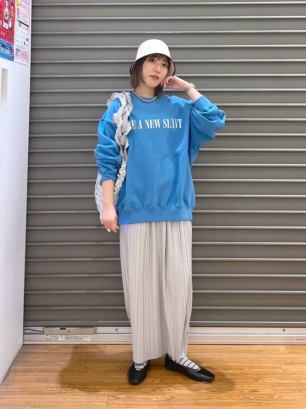 シルバー系のトートバッグ、グレー系のスカート、ブラック系のパンプスを着用したレディースの春コーディネートの1枚目の写真