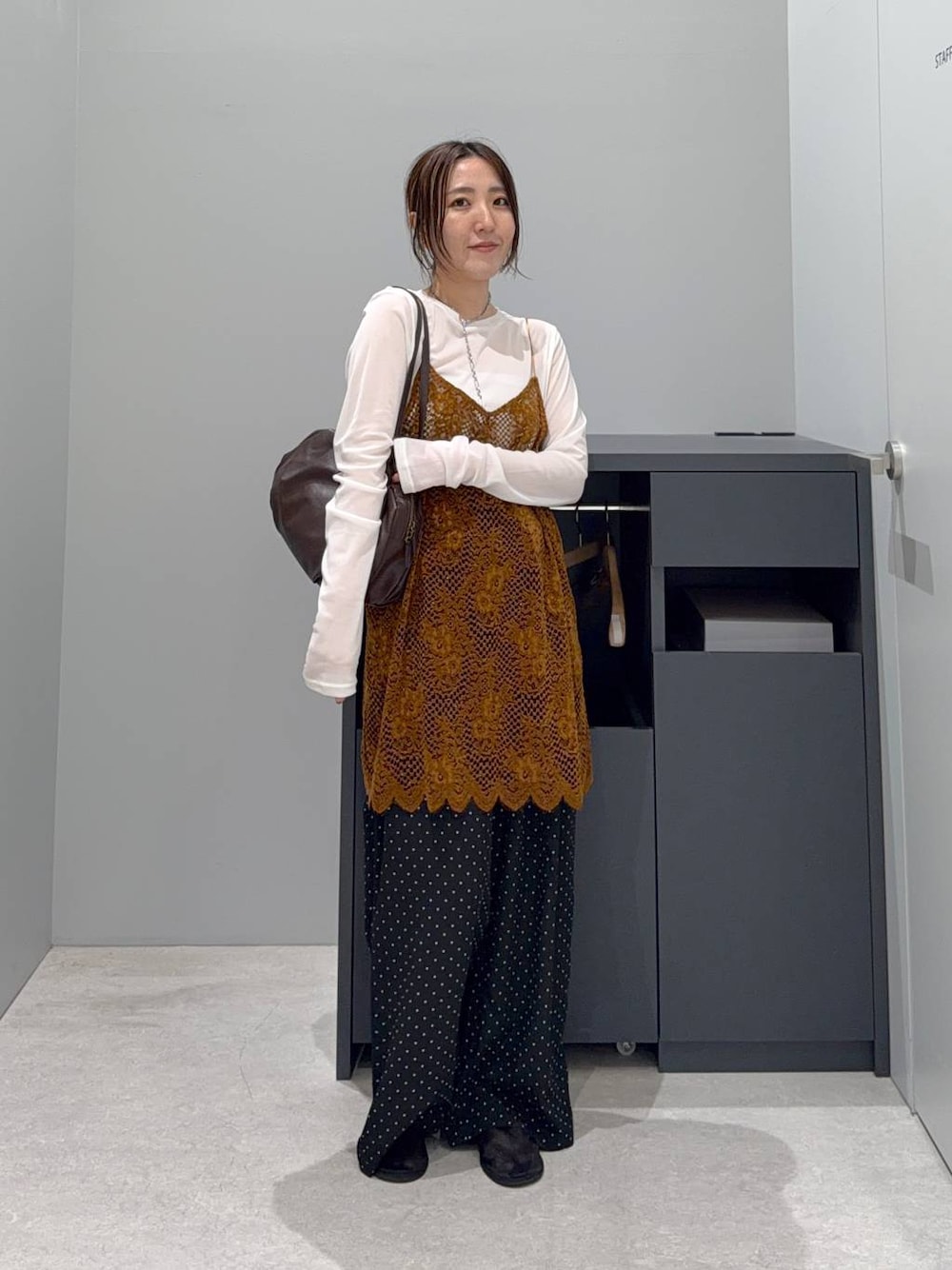 オレンジ系のキャミソール、ブラウン系のボストンバッグ、ホワイト系のTシャツ/カットソーを着用したレディースの夏コーディネートの1枚目の写真