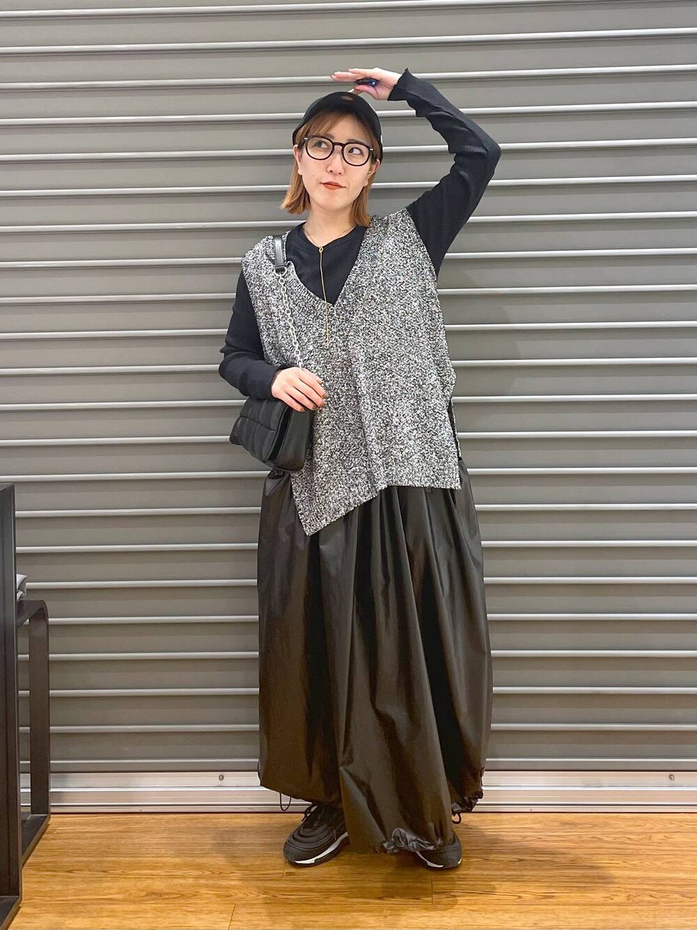 ブラック系のショルダーバッグ、ブラック系のベスト、ブラック系のTシャツ/カットソーを着用したレディースの春コーディネートの1枚目の写真