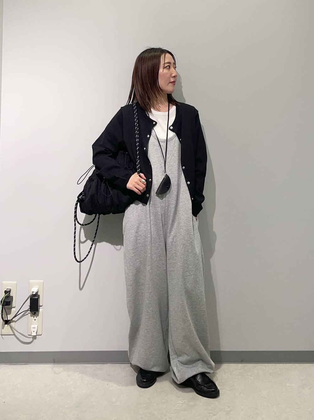 グレー系のつなぎ/オールインワン、ブラック系のバックパック/リュック、ブラック系のカーディガン/ボレロを着用したレディースの春コーディネートの1枚目の写真