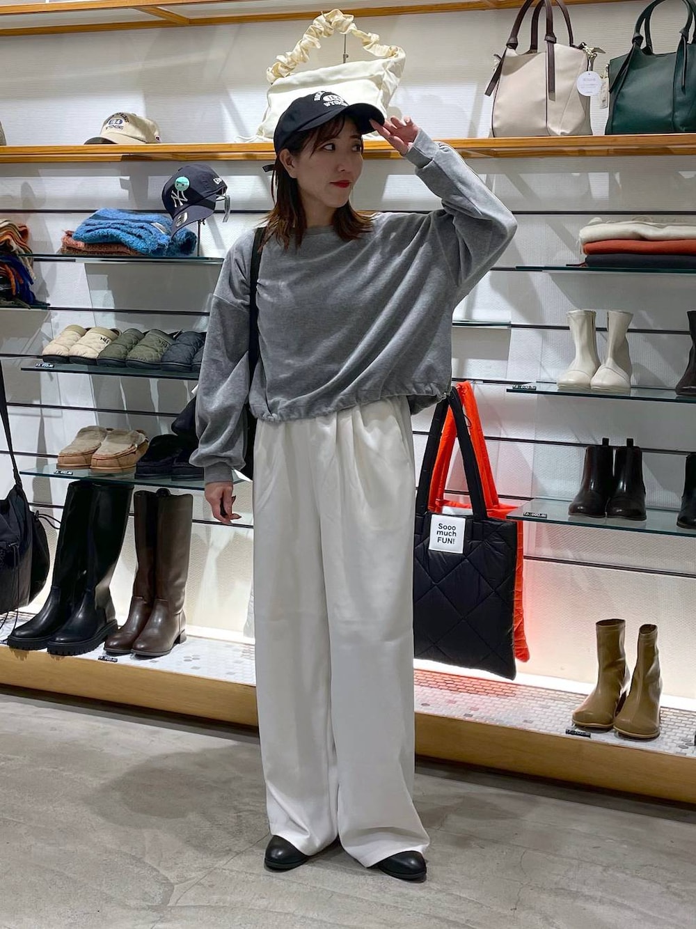 ブラック系のショルダーバッグ、ブラック系のブーツ、ホワイト系のその他パンツを着用したレディースの冬コーディネートの1枚目の写真