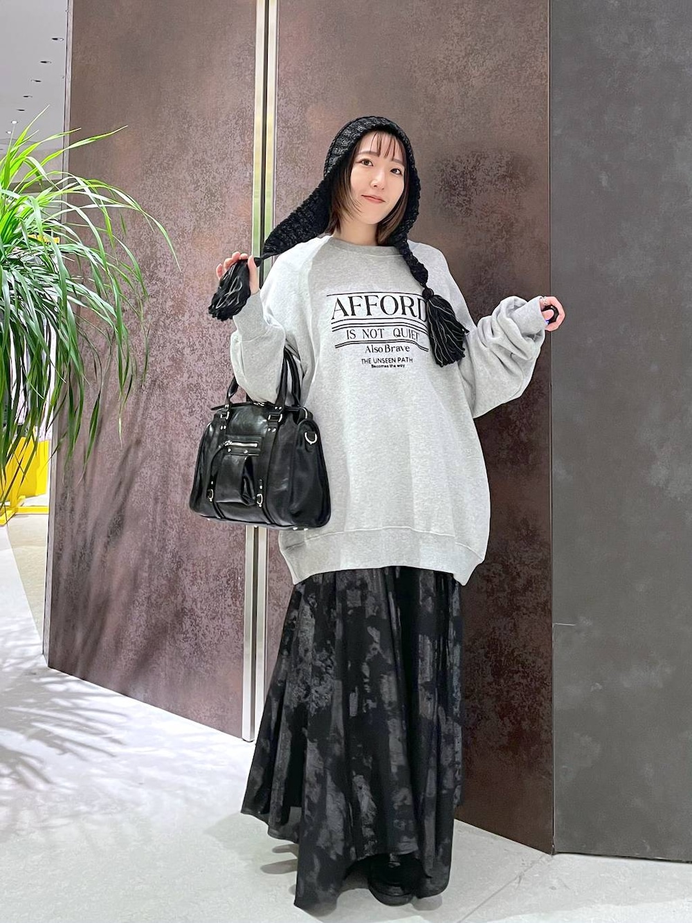 ブラック系のボストンバッグ、グレー系のスウェット、ブラック系のスカートを着用したレディースの秋コーディネートの1枚目の写真
