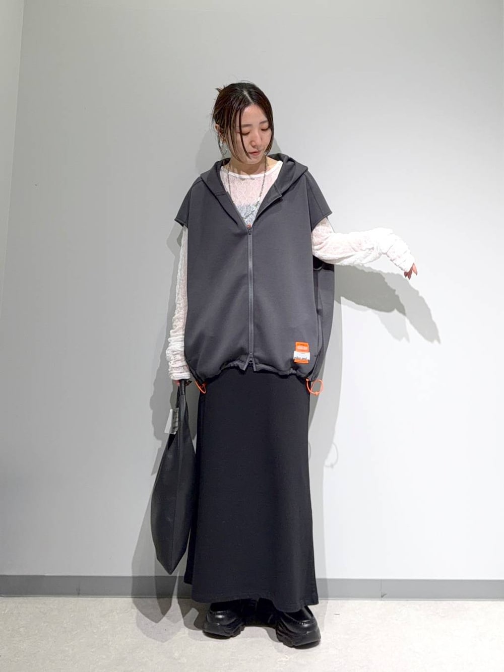 グレー系のベスト、ホワイト系のTシャツ/カットソー、ブラック系のスカートを着用したレディースの夏コーディネートの1枚目の写真