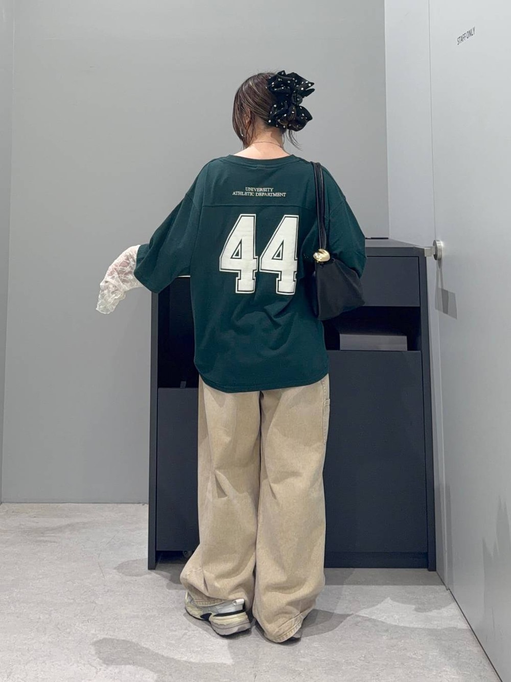 グリーン系のTシャツ/カットソー、ブラック系のショルダーバッグ、ベージュ系のデニムパンツを着用したレディースの夏コーディネートの1枚目の写真